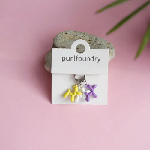 Purple, yellow and white knit stitch markers in the shape of balloon animals